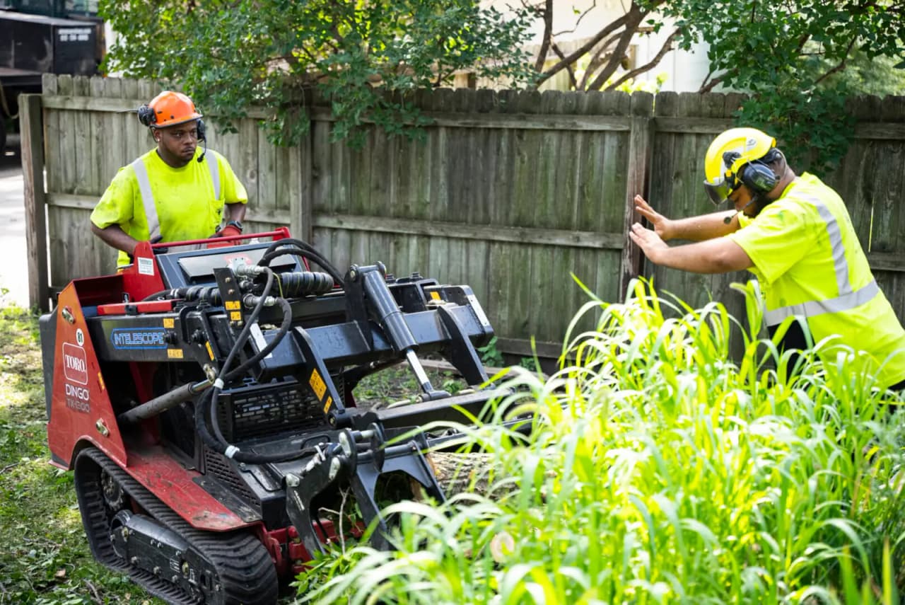 Compact loader clearing the work site